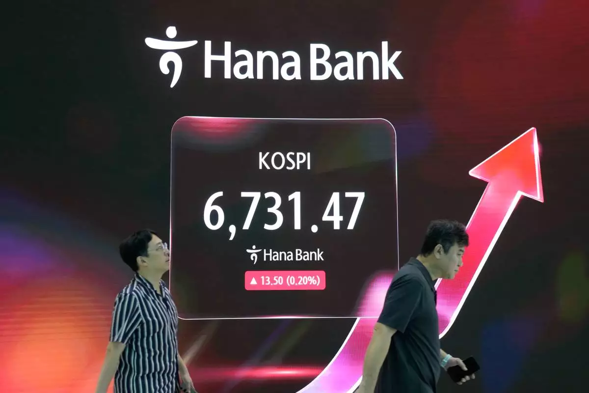 Currency traders pass by a screen showing the Korea Composite Stock Price Index (KOSPI) at the foreign exchange dealing room of the Hana Bank headquarters in Seoul, South Korea, Thursday, Sept. 17, 2026. (AP Photo/Ahn Young-joon)