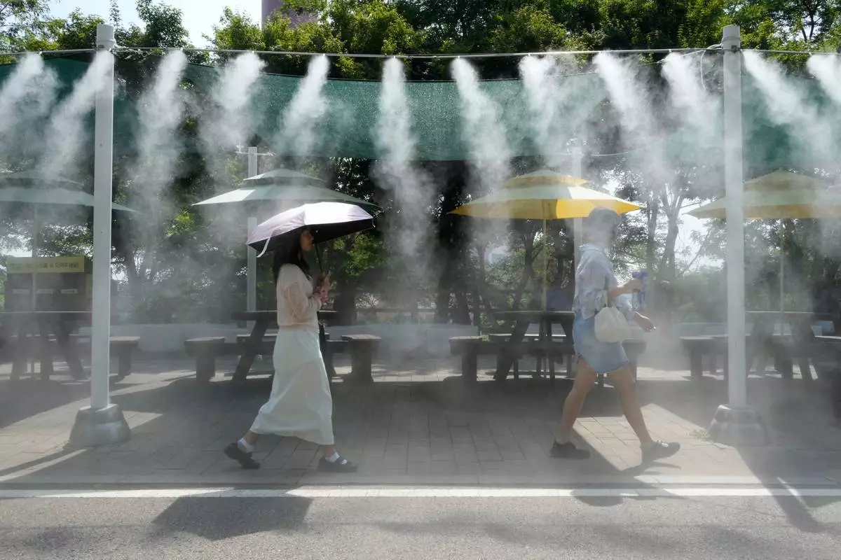 FILE - Visitors pass by the cooling fog device at Gwangmyeong Cave tourist site in Gwangmyeong, South Korea, Aug. 6, 2026. (AP Photo/Ahn Young-joon, File)
