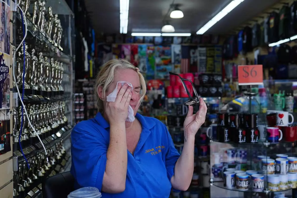 FILE - Tour operator Amanda Lovejoy wipes herself with a chilled towel in the heat Aug. 26, 2026, in the Hollywood section of Los Angeles. (AP Photo/Jae C. Hong, File)