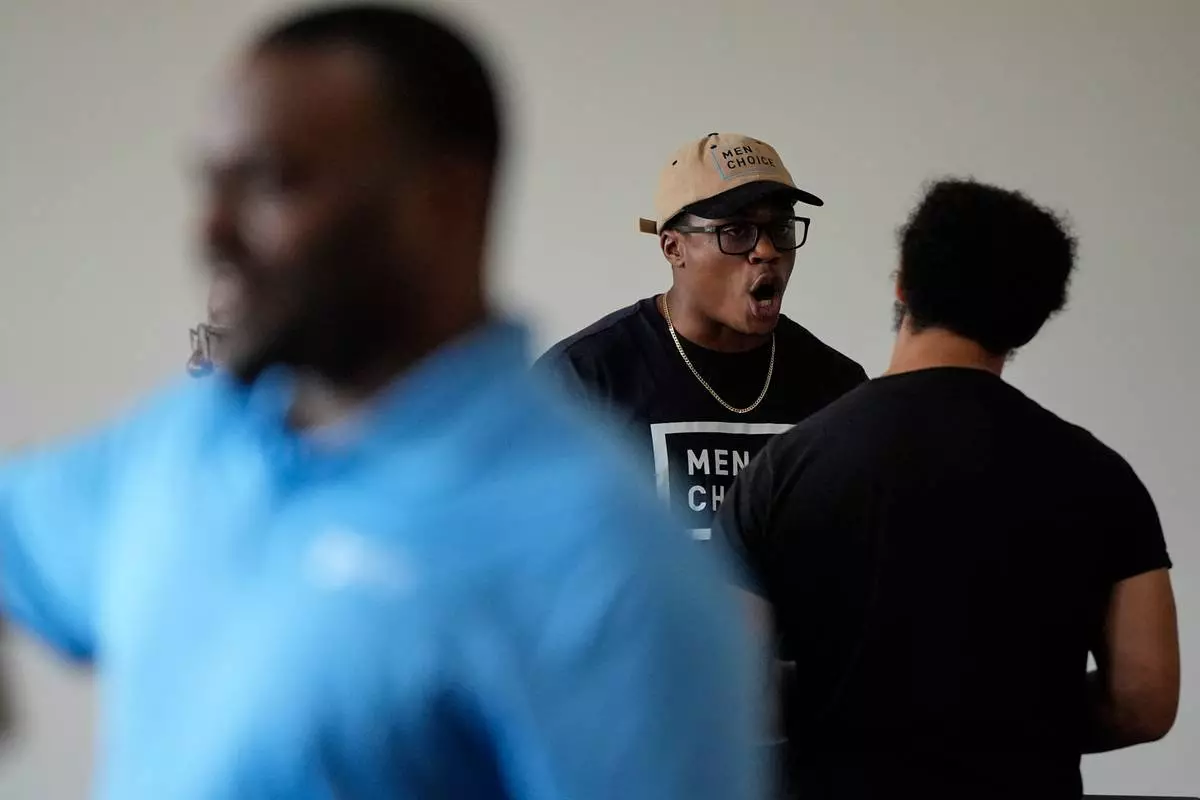 Davan'te Jennings with Men 4 Choice speaks to a person at Bridgepointe Church during an event Wednesday, Sept. 16, 2026, in Marietta, Ga. (AP Photo/Mike Stewart)