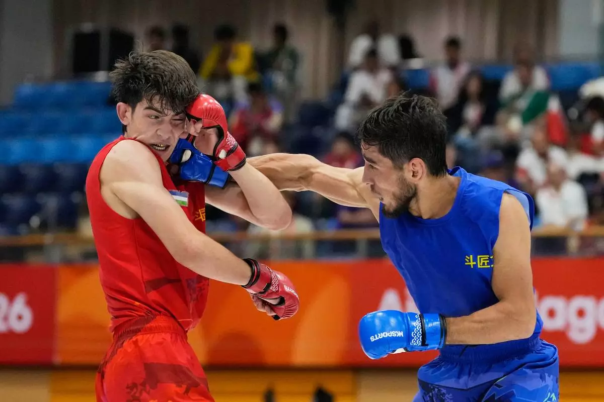 Firdaus Atamuratov of Uzbekistan, left, competes with Mirzobek Umarov of Tajikistan during their men's modern 60kg mixed martial arts final at the Asian Games in Nagoya, Japan, Tuesday, Sept. 22, 2026. (AP Photo/Dita Alangkara)