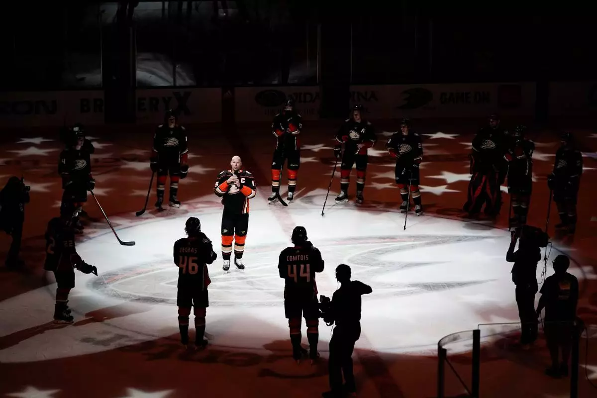 FILE - Surrounded by his teammates, Anaheim Ducks' Ryan Getzlaf addresses the fans after the team's NHL hockey game against the St. Louis Blues, April 24, 2022, in Anaheim, Calif. (AP Photo/Jae C. Hong, File)