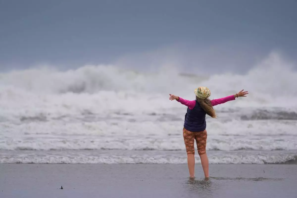 Brenda Malloy enjoys a nor'easter storm, Friday, Sept. 25, 2026, in Gloucester, Mass. (AP Photo/Robert F. Bukaty)