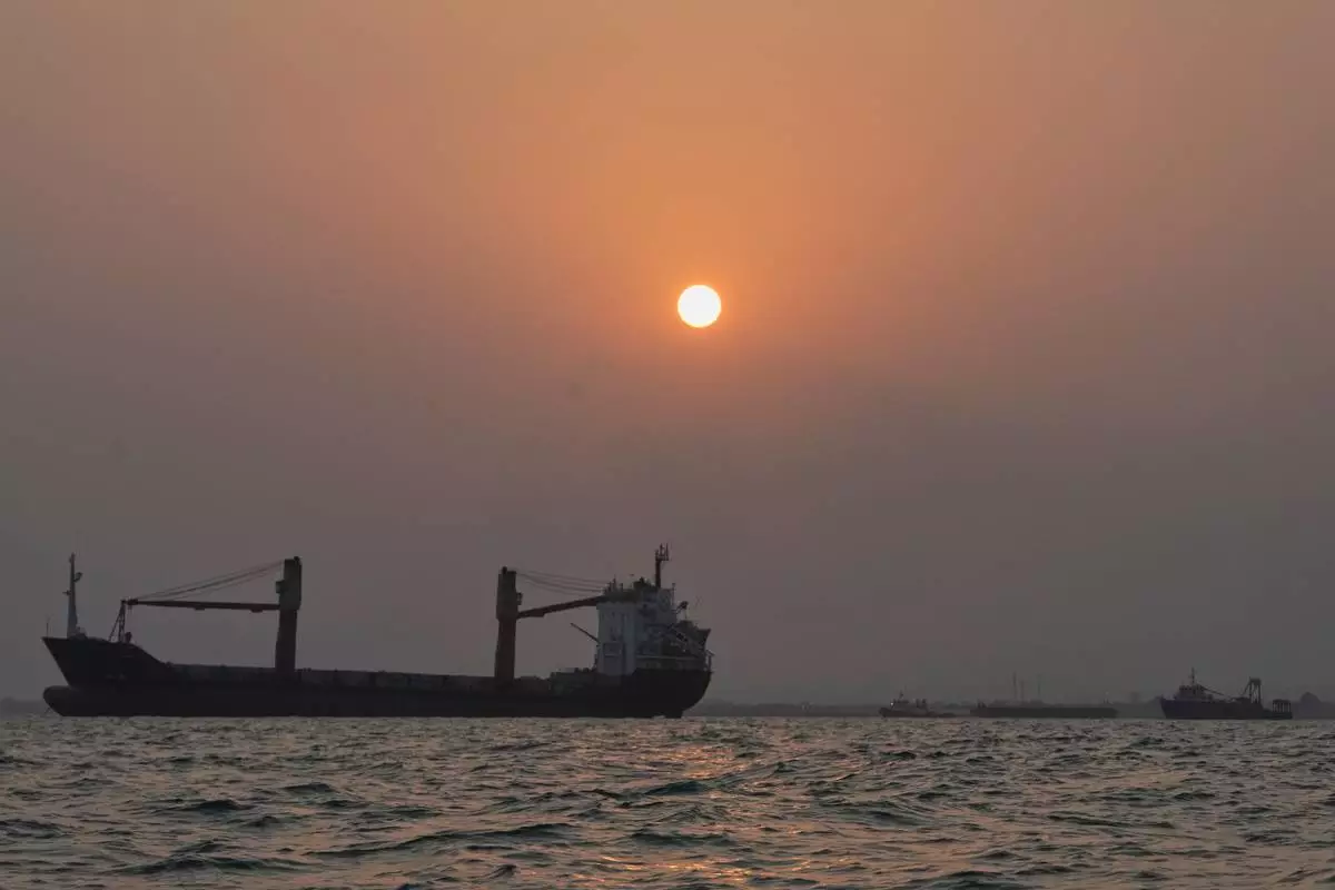 The sun sets over commercial vessels anchored in the Strait of Hormuz off Bandar Abbas, Iran, with the city's skyline in the background, Sunday, Sept. 6, 2026. (AP Photo/Vahid Salemi)