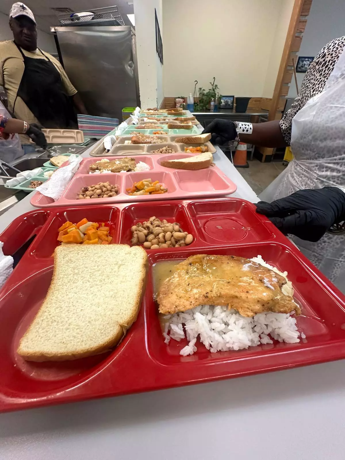 Hot lunch trays with chicken, gravy, rice and vegetables are ready to be served at Christian Service, Tuesday, Aug. 25, 2026, in Shreveport, La. (AP Photo/Lisa Mascaro)