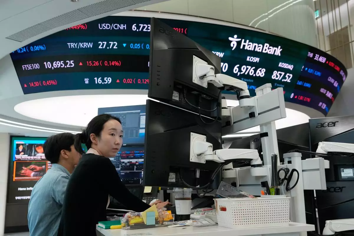 Currency traders work at the foreign exchange dealing room of the Hana Bank headquarters in Seoul, South Korea, Monday, Sept. 28, 2026. (AP Photo/Ahn Young-joon)