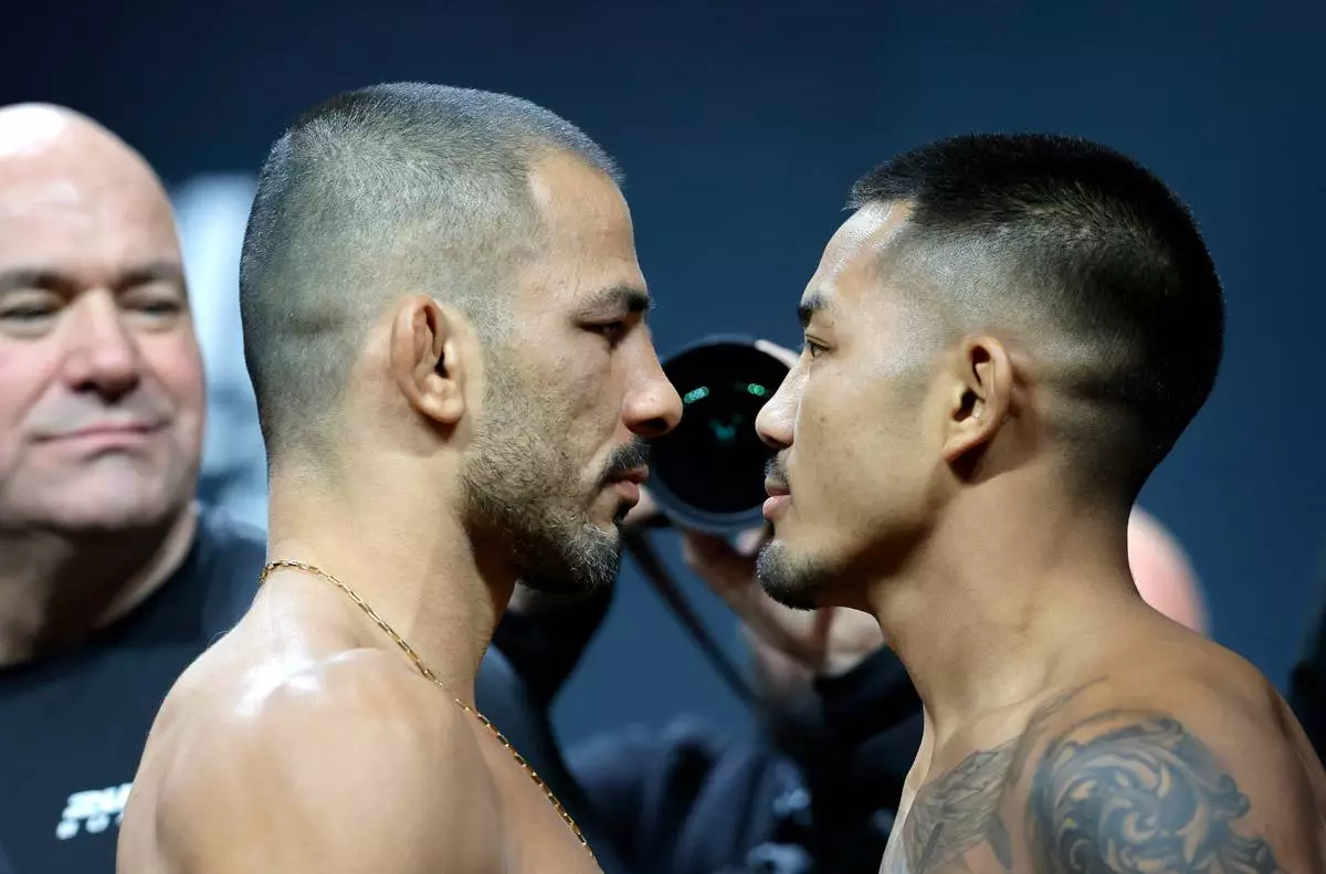 FILE - UFC flyweight champion Alexandre Pantoja, left, of Brazil, and Joshua Van, originally of Myanmar, face off during a ceremonial weigh-in for UFC 323 Friday, Dec. 5, 2025, in Las Vegas (Steve Marcus/Las Vegas Sun via AP,File)