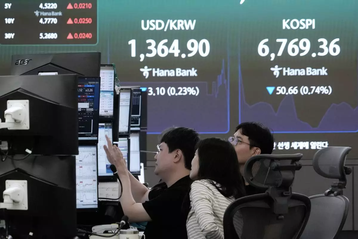 Currency traders watch monitors near a screen showing the Korea Composite Stock Price Index (KOSPI) and the foreign exchange rate between U.S. dollar and South Korean won at the foreign exchange dealing room of the Hana Bank headquarters in Seoul, South Korea, Tuesday, Sept. 1, 2026. (AP Photo/Ahn Young-joon)