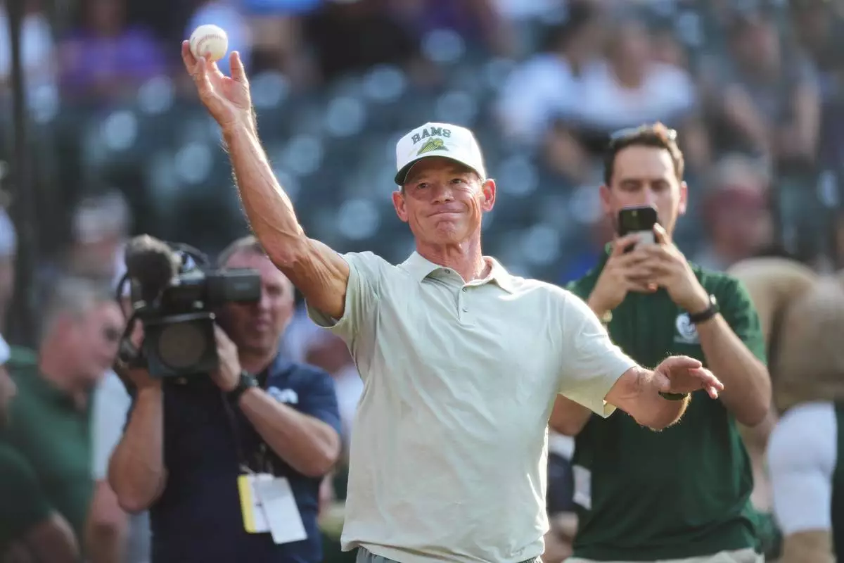 FILE - Colorado State University football head coach Jim Mora warms up before throwing the ceremonial first pitch before the Colorado Rockies host the Kansas City Royals in the first inning of a baseball game Aug. 1, 2026, in Denver. (AP Photo/David Zalubowski, File)