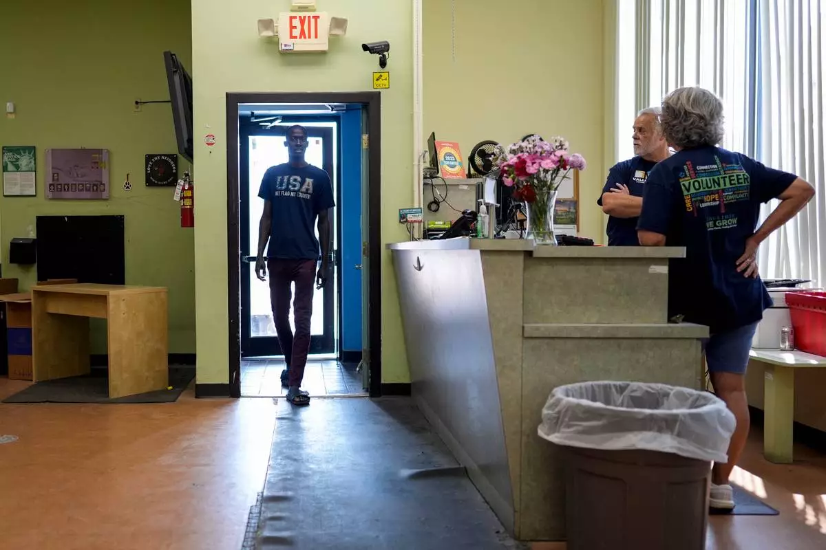 Wearing a "USA MY FLAG MY COUNTRY" T-shirt, a client walks into the Valley Interfaith Community Resource Center in Lockland, Ohio, Friday, July 31, 2026. (AP Photo/Carolyn Kaster)