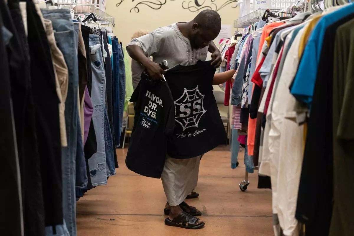Mauritanian client Allasan Darko looks through donated clothing at Valley Interfaith Community Resource Center in Lockland, Ohio, Friday, July 10, 2026. (AP Photo/Carolyn Kaster)