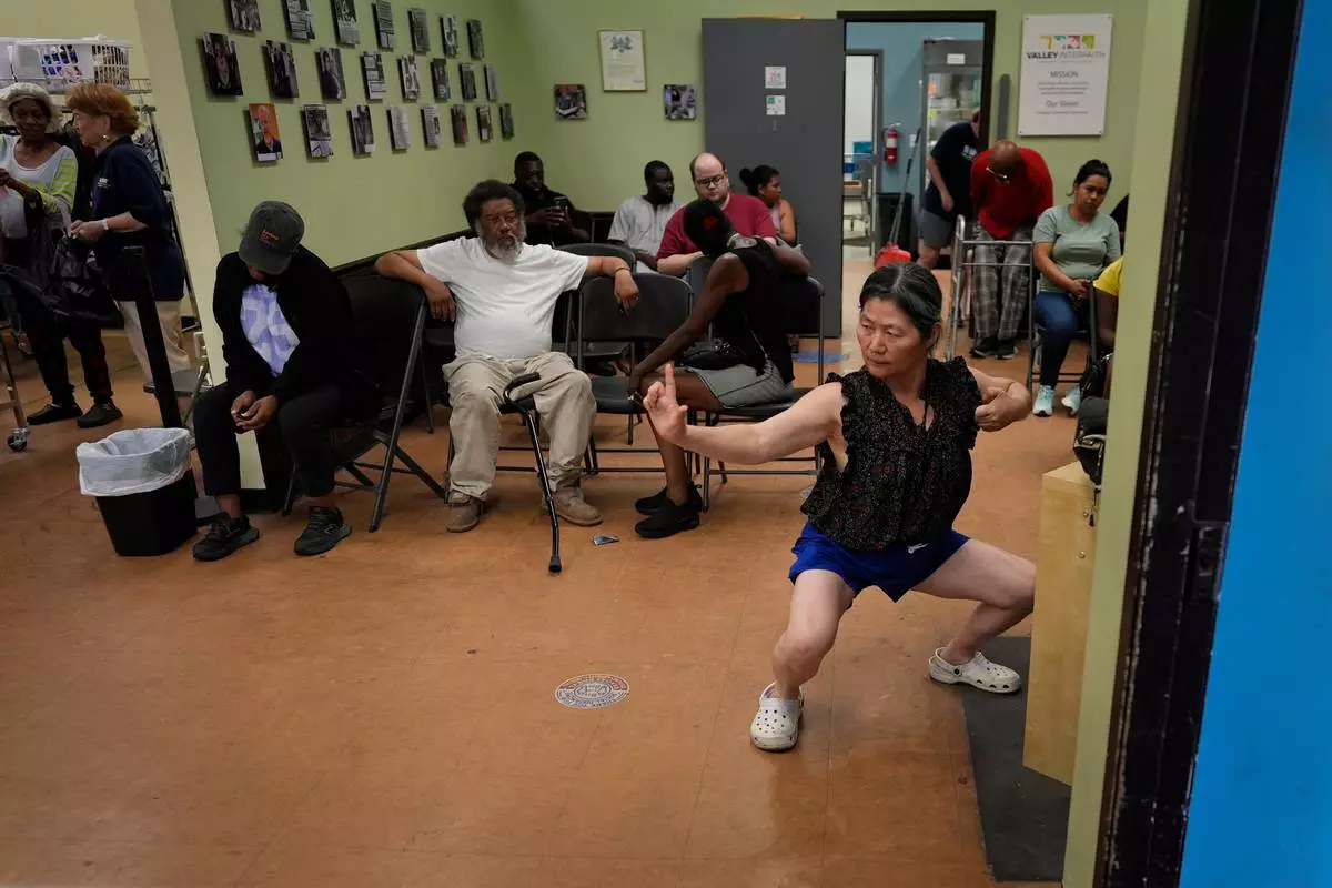 Yun Gao of China practices tai chi as she waits to receive food at Valley Interfaith Community Resource Center in Lockland, Ohio, Friday, July 10, 2026. (AP Photo/Carolyn Kaster)
