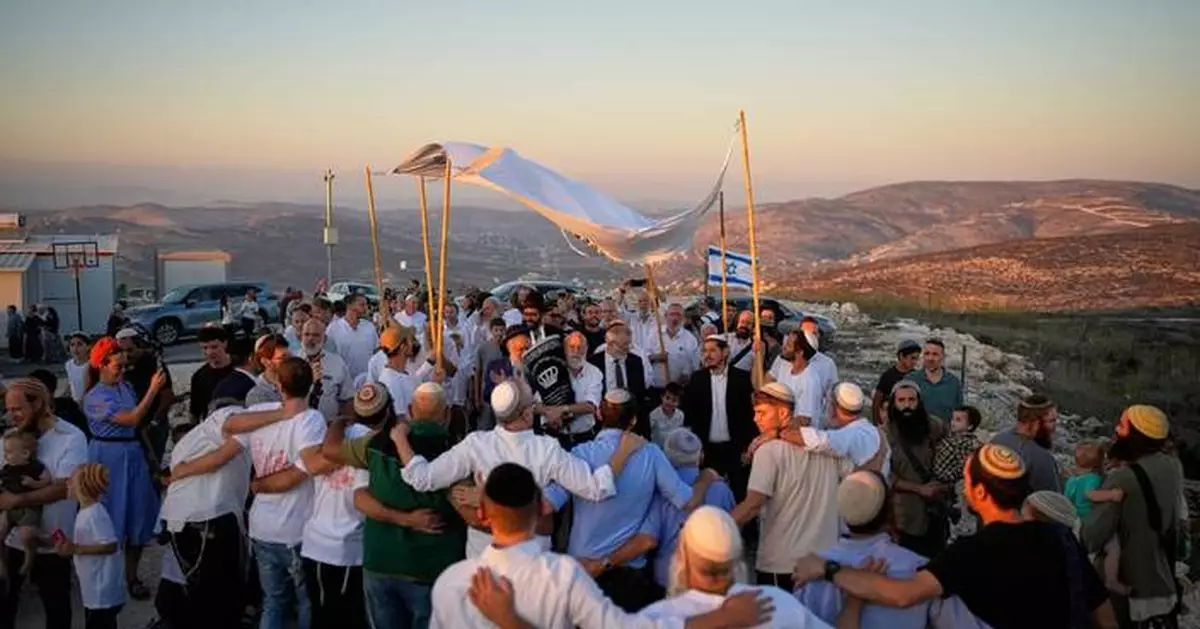 Israeli settlers, some armed, celebrate a new synagogue in the occupied West Bank, in photos