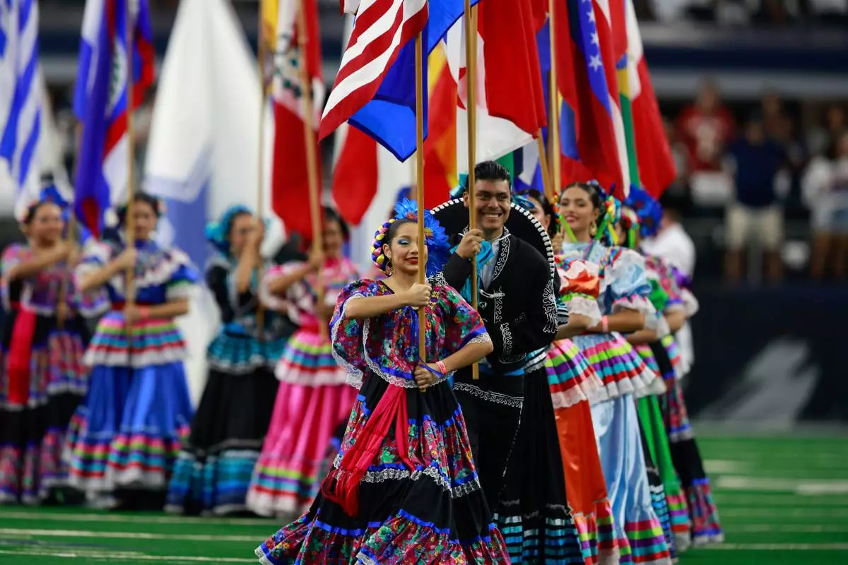 FILE - National flags from Latin American countries are displayed on the field during a celebration of Hispanic Heritage Month before an NFL football game between the Baltimore Ravens and Dallas Cowboys in Arlington, Texas, Sept. 22, 2024. (AP Photo/Gareth Patterson, File)