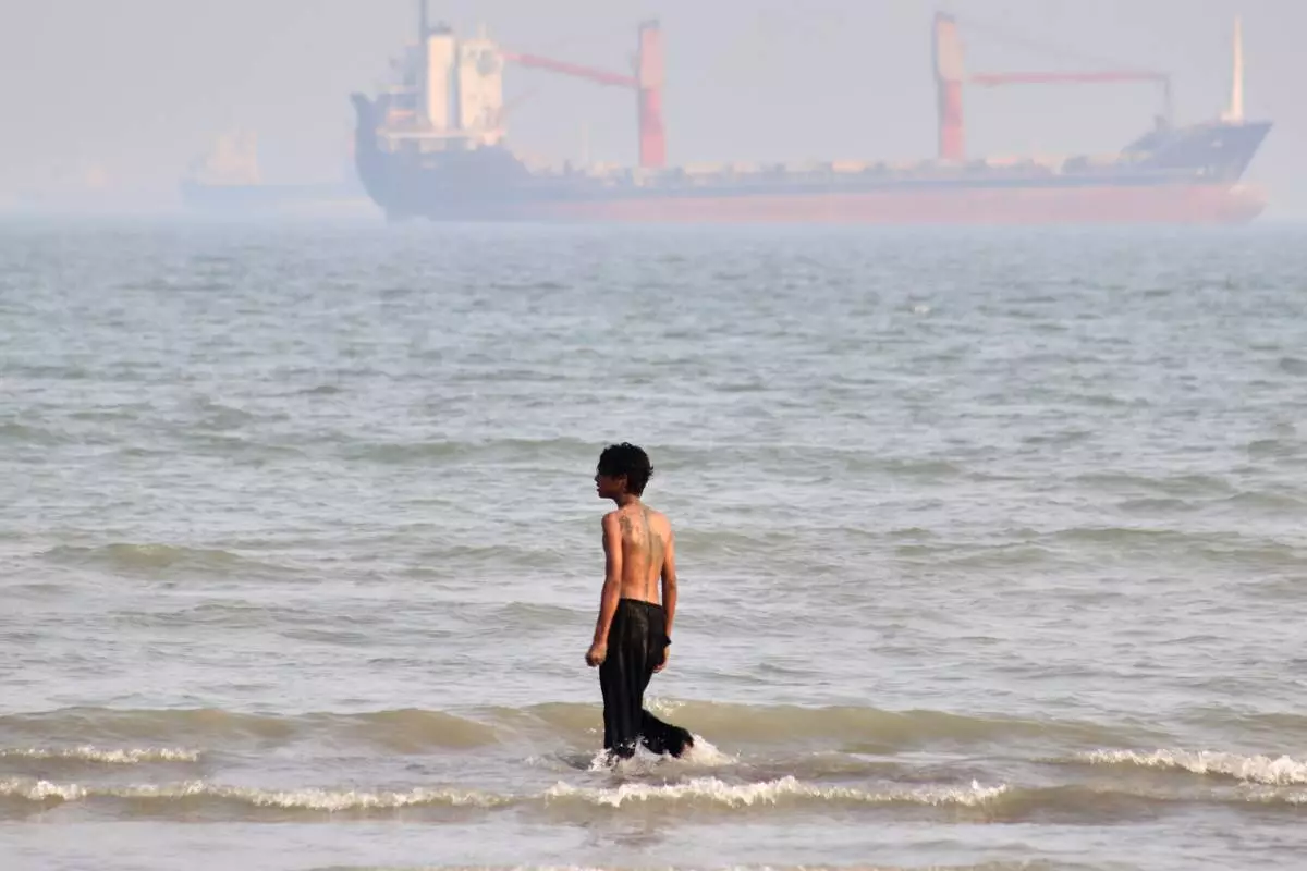 A boy walks on shallow water as commercial vessels are anchored in the Strait of Hormuz off Bandar Abbas, Iran, Monday, Aug. 31, 2026. (Razieh Poudat/ISNA via AP)