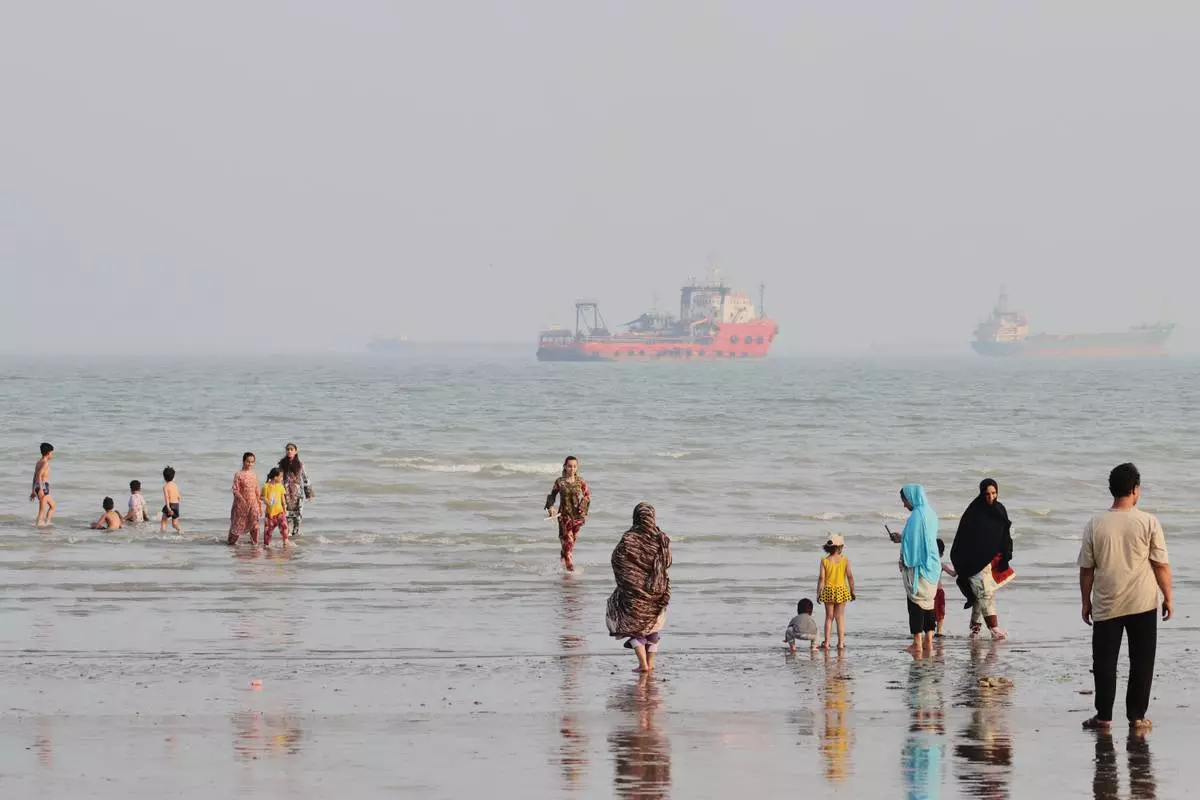 People spend time at a beach as commercial vessels are anchored in the Strait of Hormuz off Bandar Abbas, Iran, Monday, Aug. 31, 2026. (Razieh Poudat/ISNA via AP)