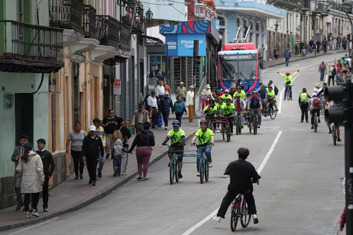 FILE - Volunteers with the "Ciegocleta" initiative guide visually impaired participants on tandem bicycles in Quito, Ecuador, Sunday, Aug. 30, 2026. (AP Photo/Dolores Ochoa)