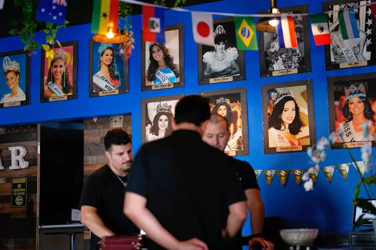 Photos of Venezuelan Miss Universe contestants line a wall at Arempa's restaurant Tuesday, July 14, 2026, in Midvale, Utah. (AP Photo/Gregory Bull)