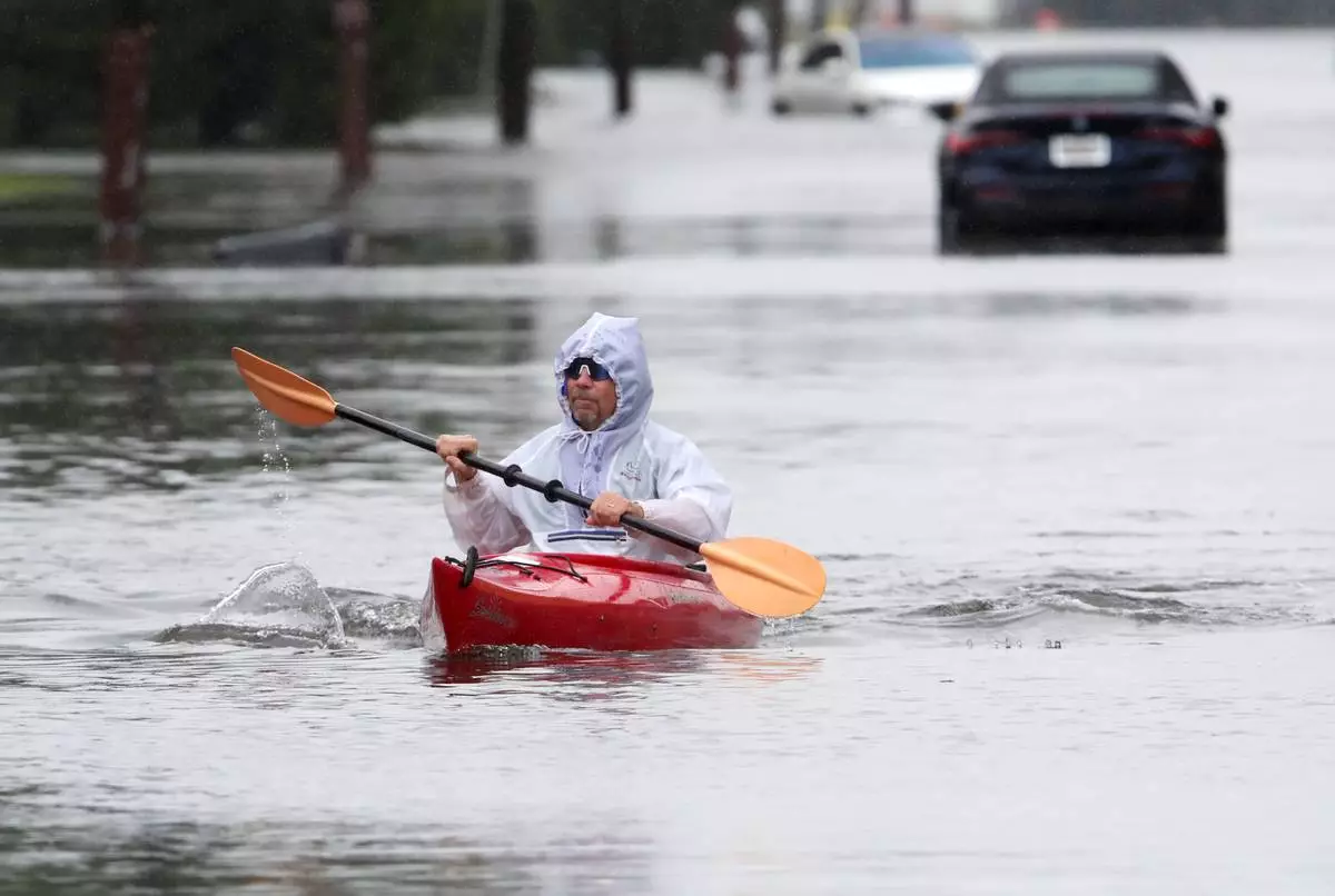 Ted Friedli kayaks his way through a flooded section of Florence Ave. during a nor'easter in Long Branch, N.J., Saturday, Sept. 26, 2026 (AP Photo/Noah K. Murray)