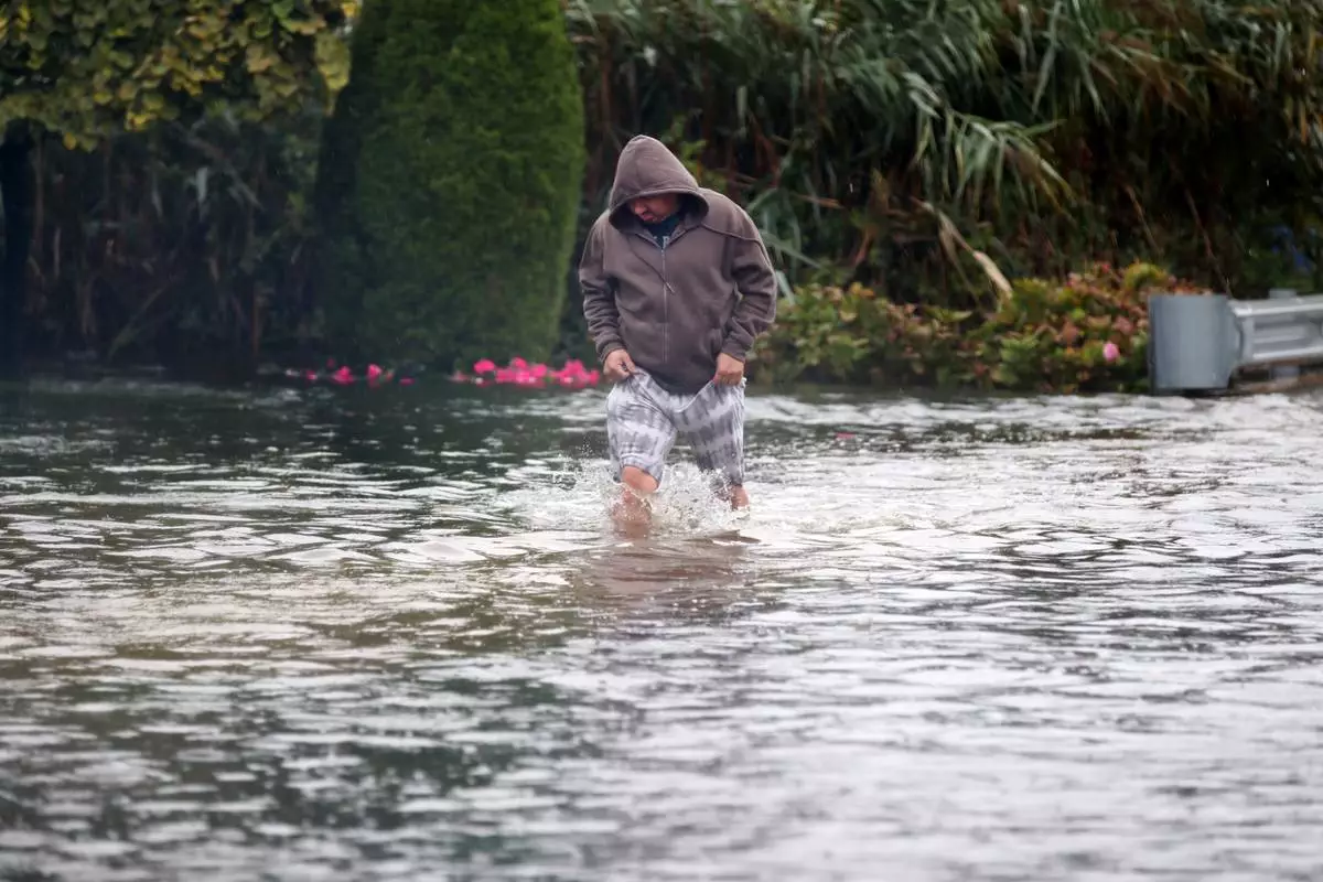 Alberto Montalvo wades through a flooded section of Atlantic Ave. during a nor'easter storm in Long Branch, N.J., Saturday, Sept. 26, 2026. (AP Photo/Noah K. Murray)