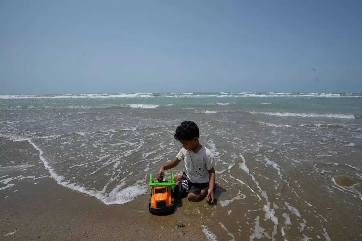 A boy plays with a toy truck on a beach along the Strait of Hormuz in Kuhestak, Iran, Friday, Sept. 4, 2026. (AP Photo/Vahid Salemi)