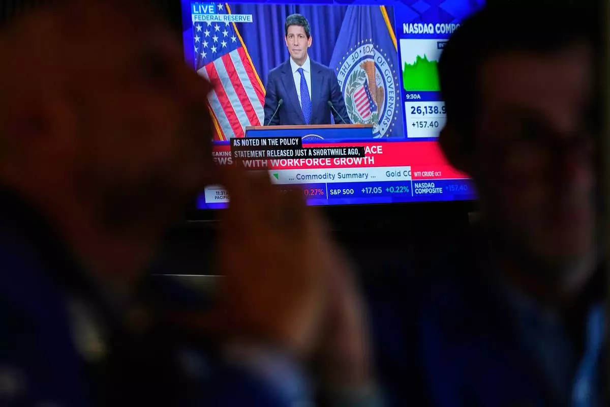 Screens display a news conference held by Federal Reserve chairman Kevin Warsh on the floor of the New York Stock Exchange in New York, Wednesday, Sept. 16, 2026. (AP Photo/Seth Wenig)