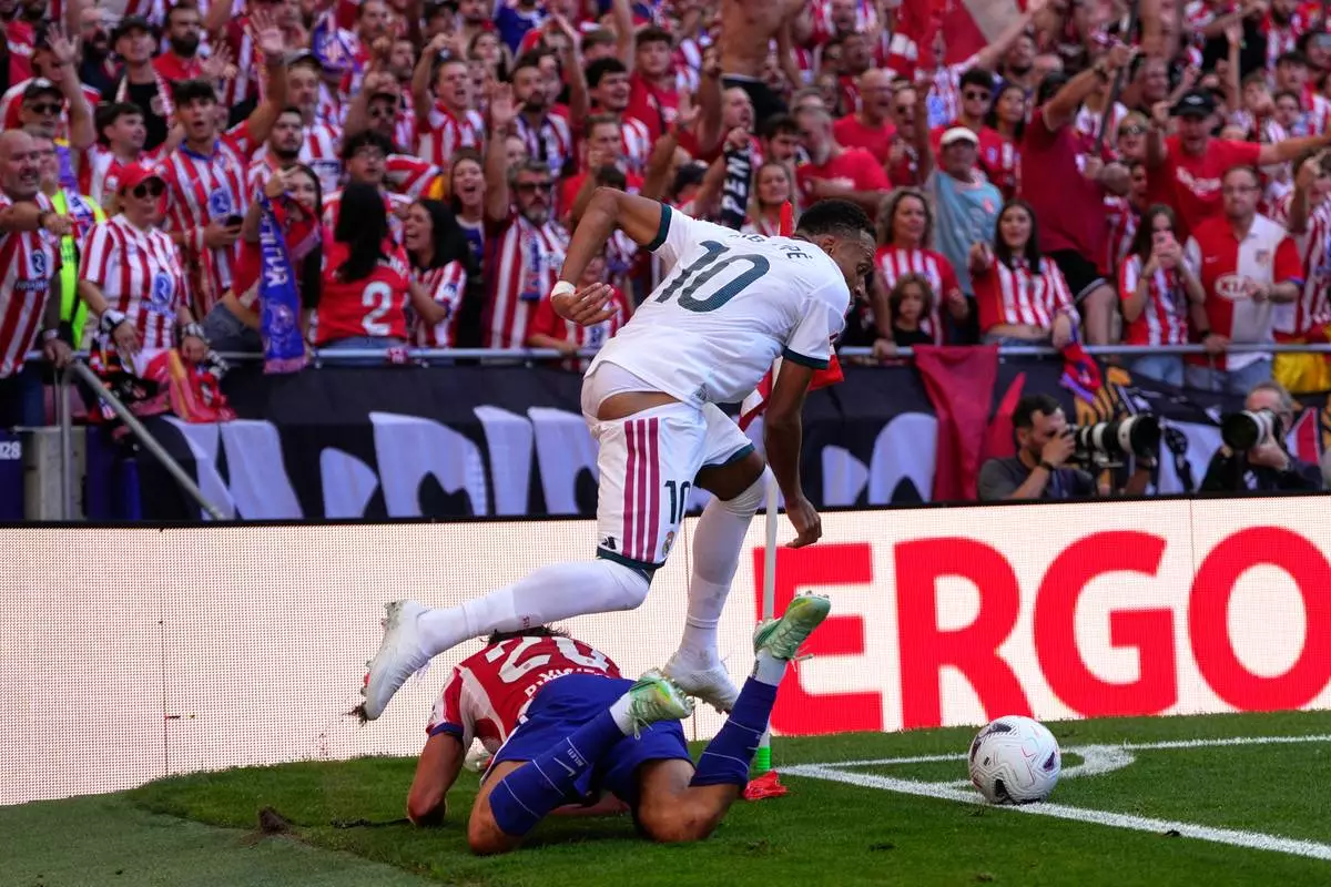 Atletico Madrid fans react as Atletico Madrid's Giuliano Simeone falls to the ground in a clash with Real Madrid's Kylian Mbappe during a Spanish La Liga soccer match between Atletico Madrid and Real Madrid in Madrid, Sunday, Sept. 20, 2026. (AP Photo/Bernat Armangue)