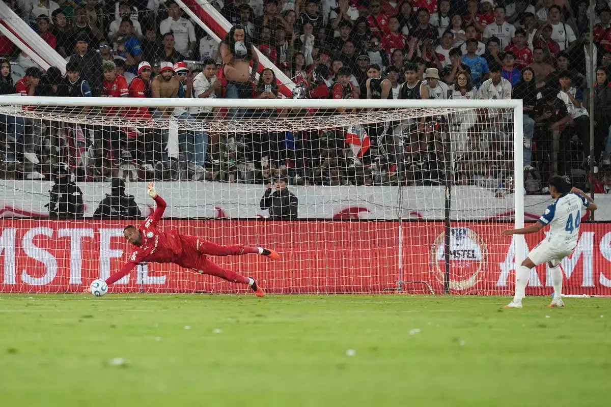 Goalkeeper Carlos Miguel of Brazil's Palmeiras saves a penalty by Luis Segovia of Ecuador's Liga Deportiva Universitaria in a shootout during a Copa Libertadores quarterfinal second leg soccer match in Quito, Ecuador, Wednesday, Sept. 16, 2026. (AP Photo/Dolores Ochoa)
