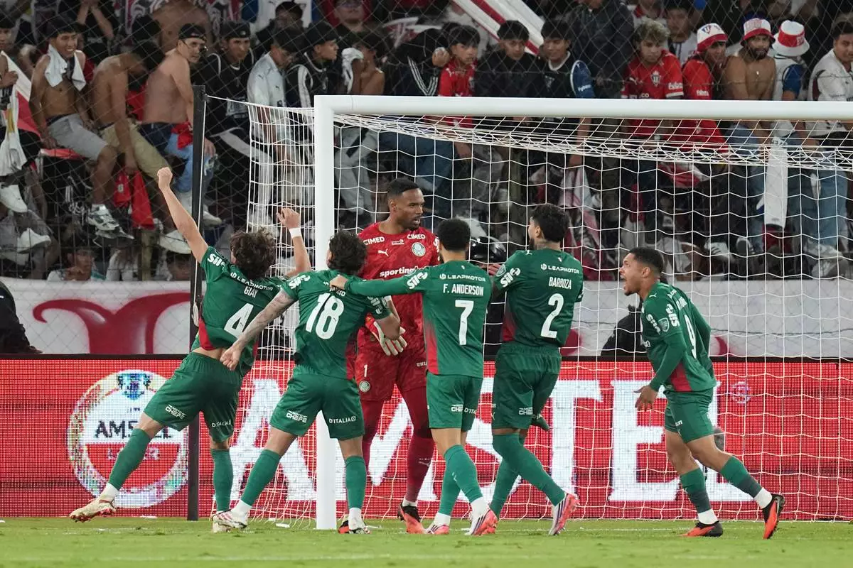 Goalkeeper Carlos Miguel of Brazil's Palmeiras, center, celebrates with teammates at the end of the Copa Libertadores quarterfinal second leg soccer match against Ecuador's Liga Deportiva Universitaria in Quito, Ecuador, Wednesday, Sept. 16, 2026. (AP Photo/Dolores Ochoa)