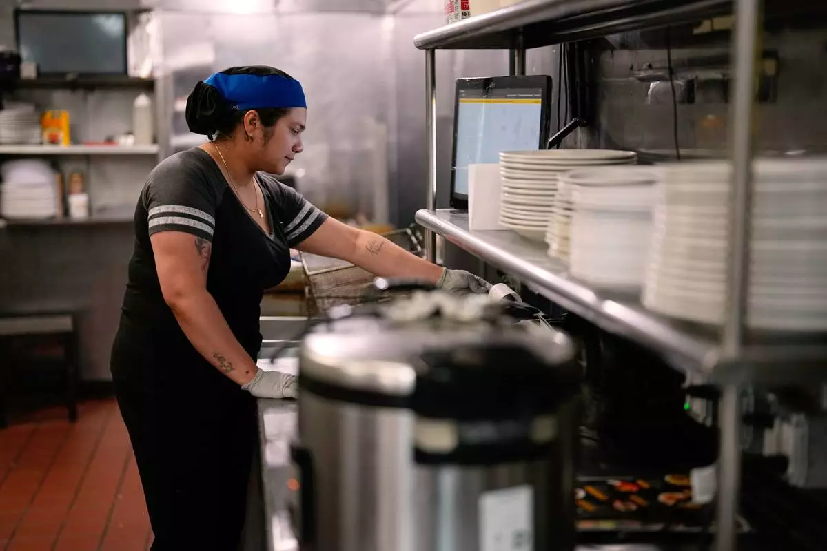 Dayana Ortega works at an Arempa's restaurant Tuesday, July 14, 2026, in Midvale, Utah. (AP Photo/Gregory Bull)