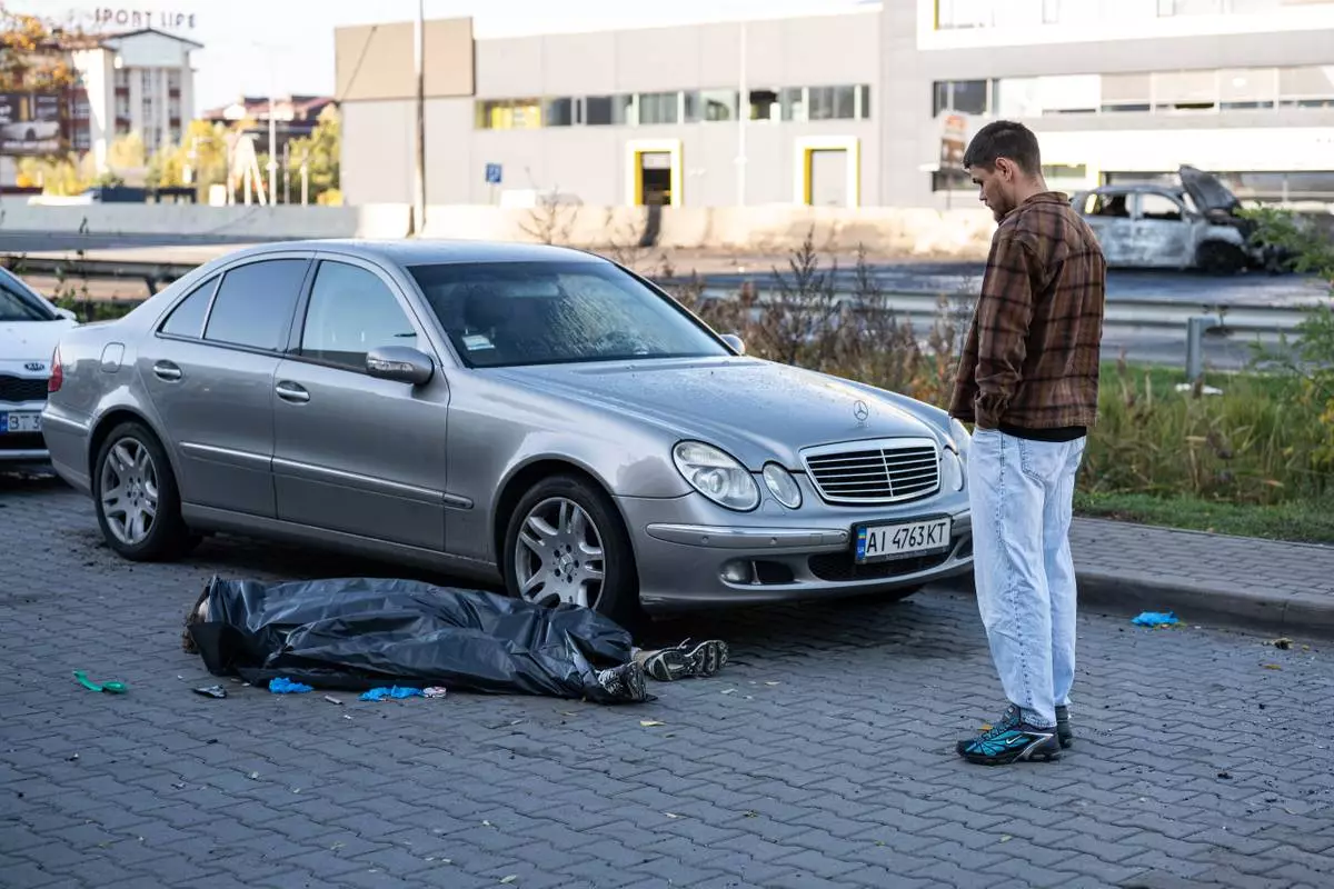 A man looks at a body of a man killed in a Russian strike on Chabany, near Kyiv, Ukraine, Tuesday, Oct. 20, 2026. (AP Photo/Danylo Antoniuk) CORRECTION: Byline is Danylo Antoniuk, not Dan Bashakov.