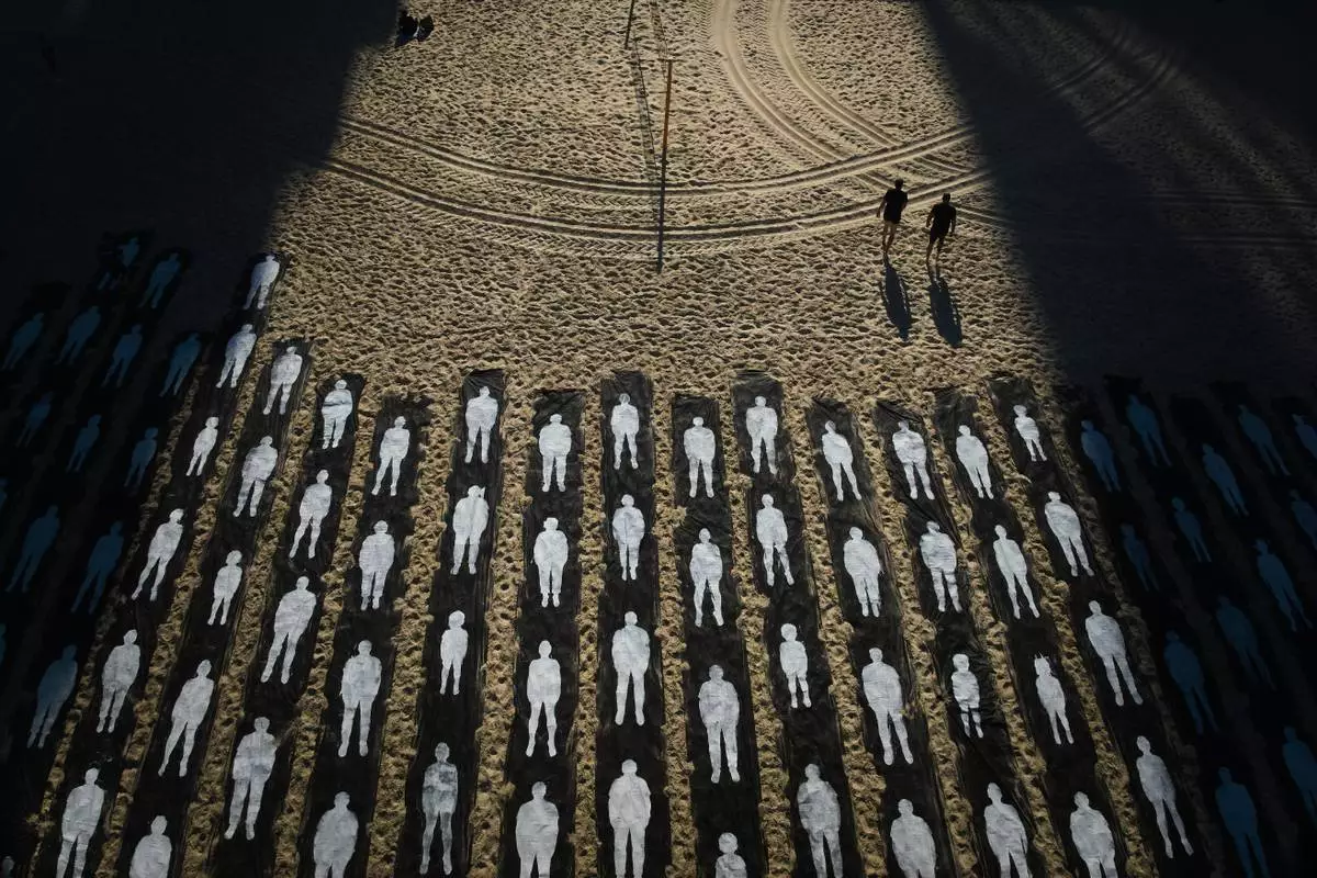 People walk past an installation marking the third anniversary of the Oct. 7, 2023, Hamas attack on Israel, on the beachfront in Tel Aviv, Israel, Wednesday, Oct. 7, 2026. (AP Photo/Oded Balilty)