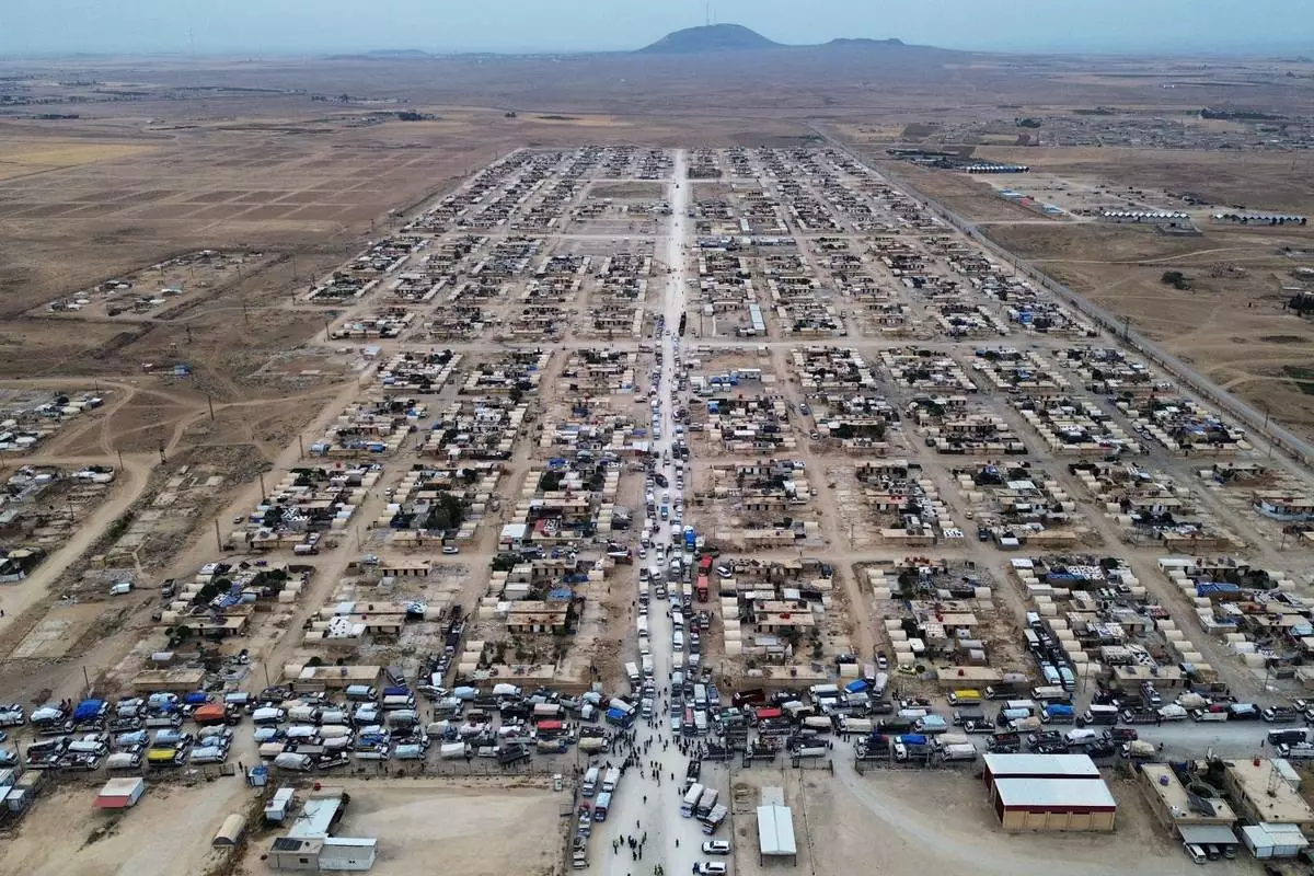Trucks packed with belongings line the roads at al-Talayi camp as displaced families get ready to return to the Ras al-Ayn countryside, in Hassakeh, Syria, Tuesday, Oct. 13, 2026. Around 450 families are making the journey after seven years of displacement following a Turkish military offensive in 2019. (AP Photo/Baderkhan Ahmad)