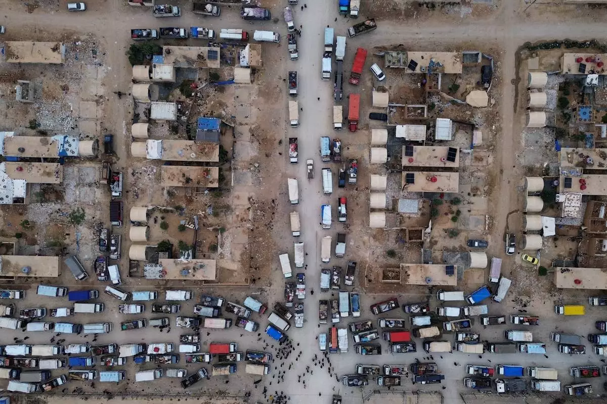 Trucks packed with belongings line the roads at al-Talayi camp as displaced families get ready to return to the Ras al-Ayn countryside, in Hassakeh, Syria, Tuesday, Oct. 13, 2026. Around 450 families are making the journey after seven years of displacement following a Turkish military offensive in 2019. (AP Photo/Baderkhan Ahmad)