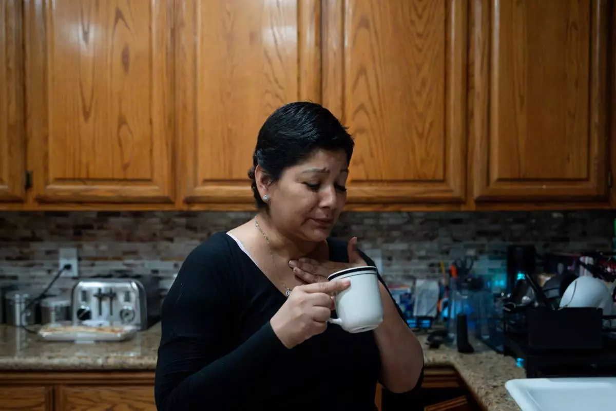 Cindy Banda drinks a home remedy after experiencing side effects from the targeted therapy pill Kisqali, Sept. 16, 2026, at her house in McAllen, Texas. (AP Photo/Julia Demaree Nikhinson)