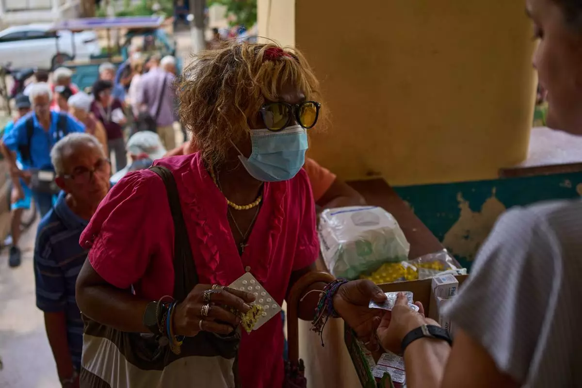 A woman receives medicine distributed through the “Medicine Is Not for Sale” community project in Havana, Cuba, Thursday, Oct. 8, 2026. (AP Photo/Ramon Espinosa)