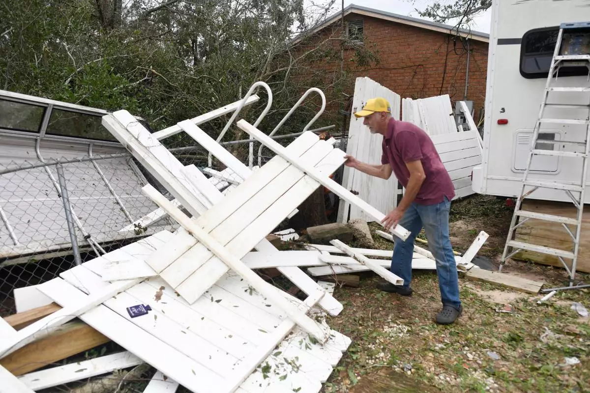 Curt Brown picks up debris left by Isaias around his RV home on Saturday, Oct. 10, 2026, in Milton, Fla. (AP Photo/Octavio Jones)