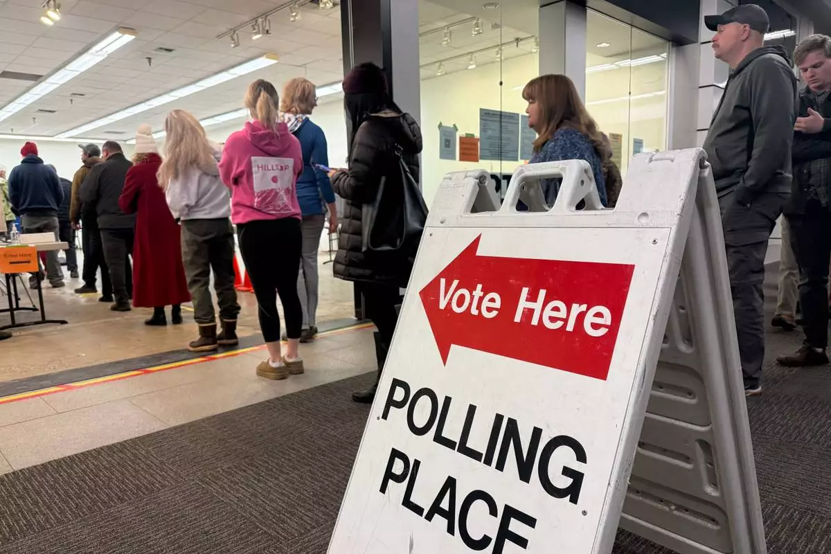 This photo taken with a smart phone, voters stand in line at an early voting location in a mall in Anchorage, Alaska, on Wednesday, Oct. 21, 2026. (AP Photo/Haven Daley)