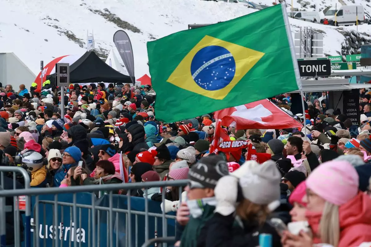 Supporters of Brazil's Lucas Pinheiro Braathen wave a Brazilian flag during an alpine ski, men's World Cup giant slalom, in Soelden, Austria, Sunday, Oct. 25, 2026. (AP Photo/Alessandro Trovati)