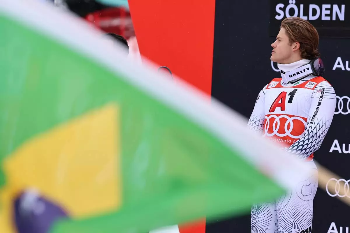 Brazil's Lucas Pinheiro Braathen listens to the national anthem on the podium after winning an alpine ski, men's World Cup giant slalom, in Soelden, Austria, Sunday, Oct. 25, 2026. (AP Photo/Marco Trovati)