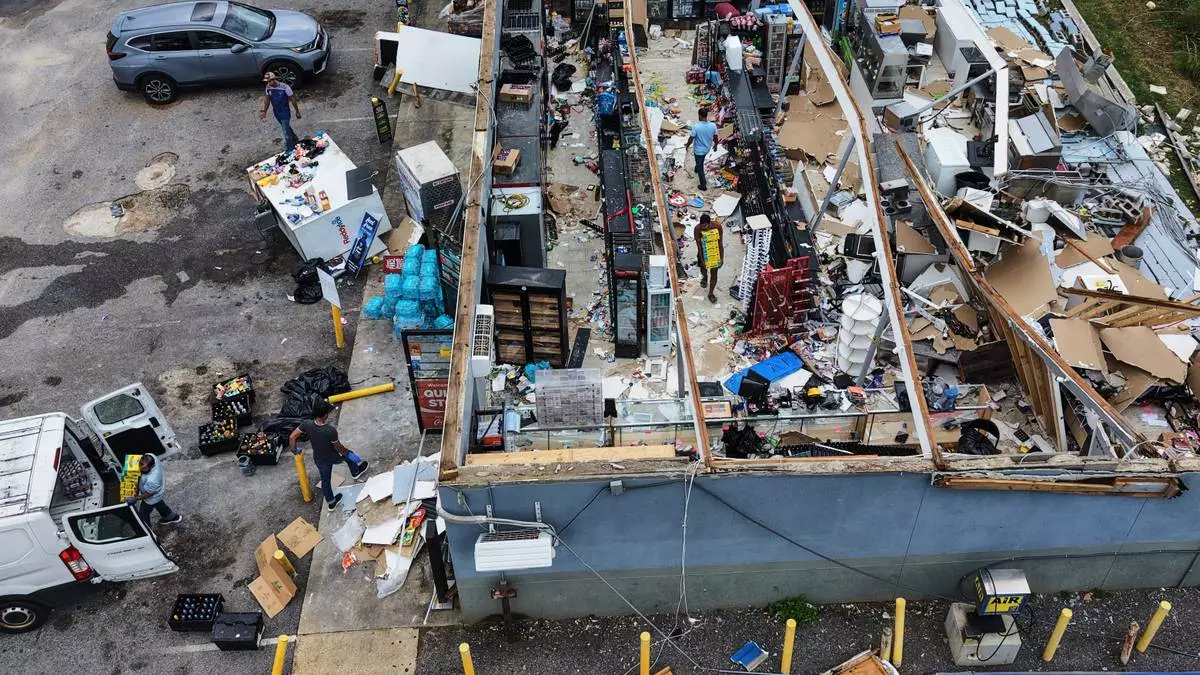 People salvage the contents of their destroyed mini mart in the aftermath of Hurricane Isaias in Milton, Fla., Saturday, Oct. 10, 2026. (AP Photo/Gerald Herbert)