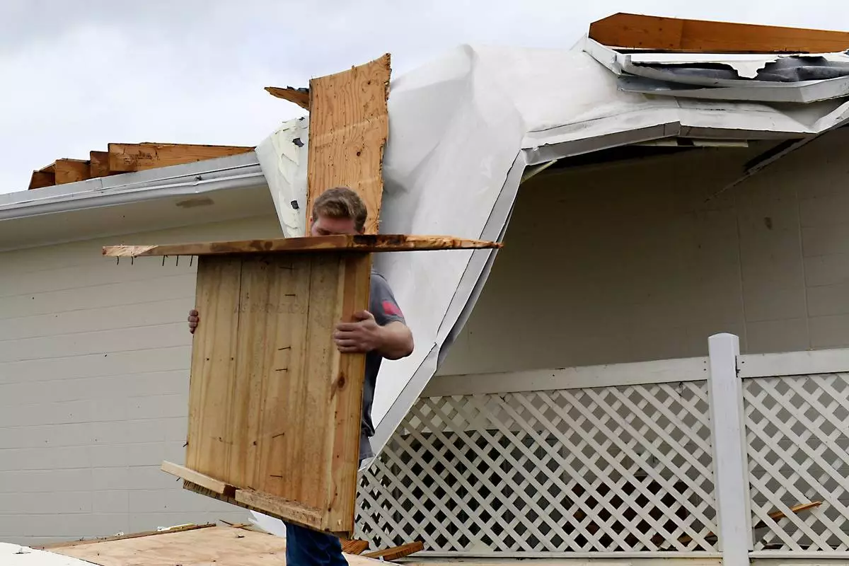 Jonathan Poston, of Lewis Funeral Home, cleans up storm debris left by Isaias on Saturday, Oct. 10, 2026, in Milton, Fla. (AP Photo/Octavio Jones)