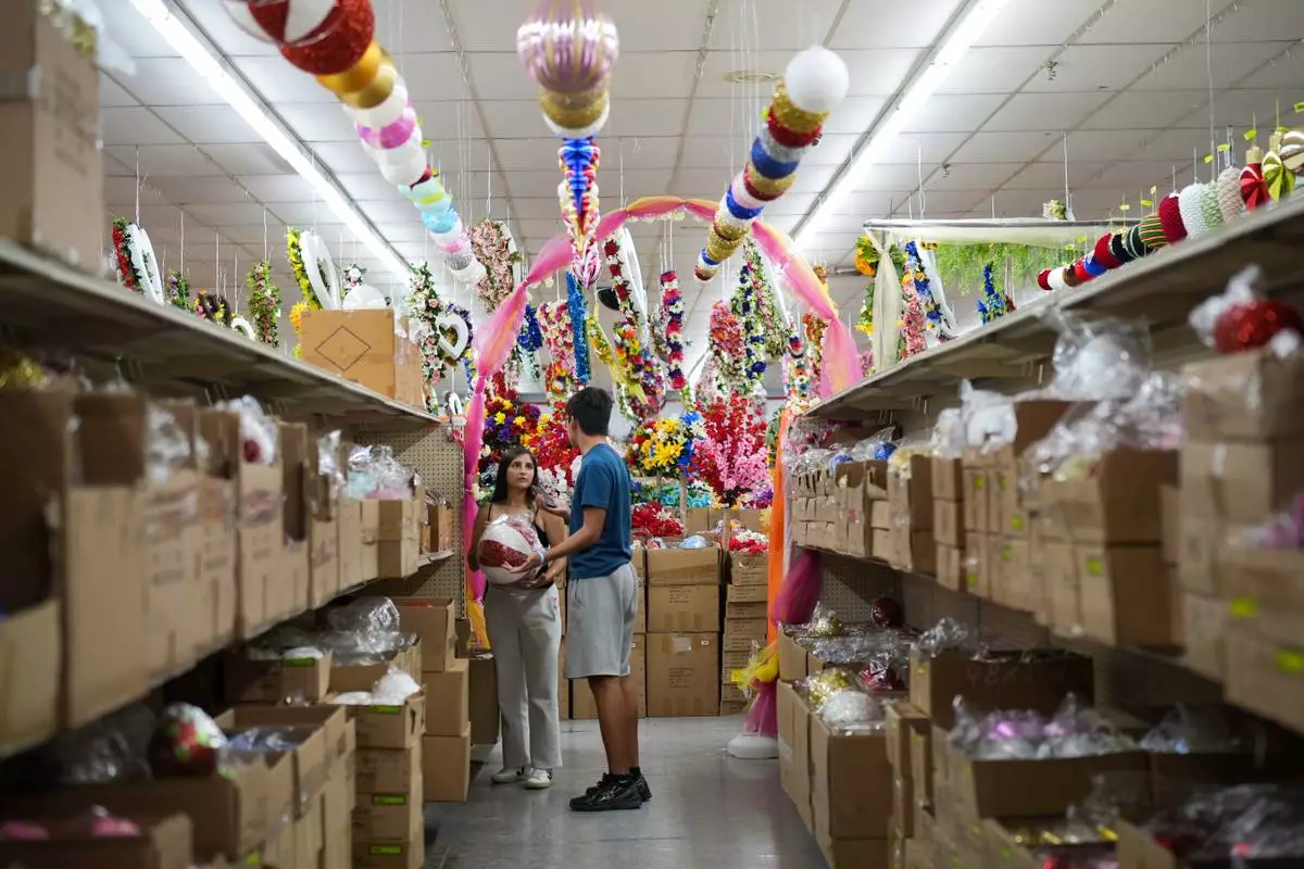Siblings Kimberly Ford and Richard "Trey" Ford III shop for flowers at Floreria Lee for their mother's tomb plate, Sept. 14, 2026, in McAllen, Texas. (AP Photo/Julia Demaree Nikhinson)