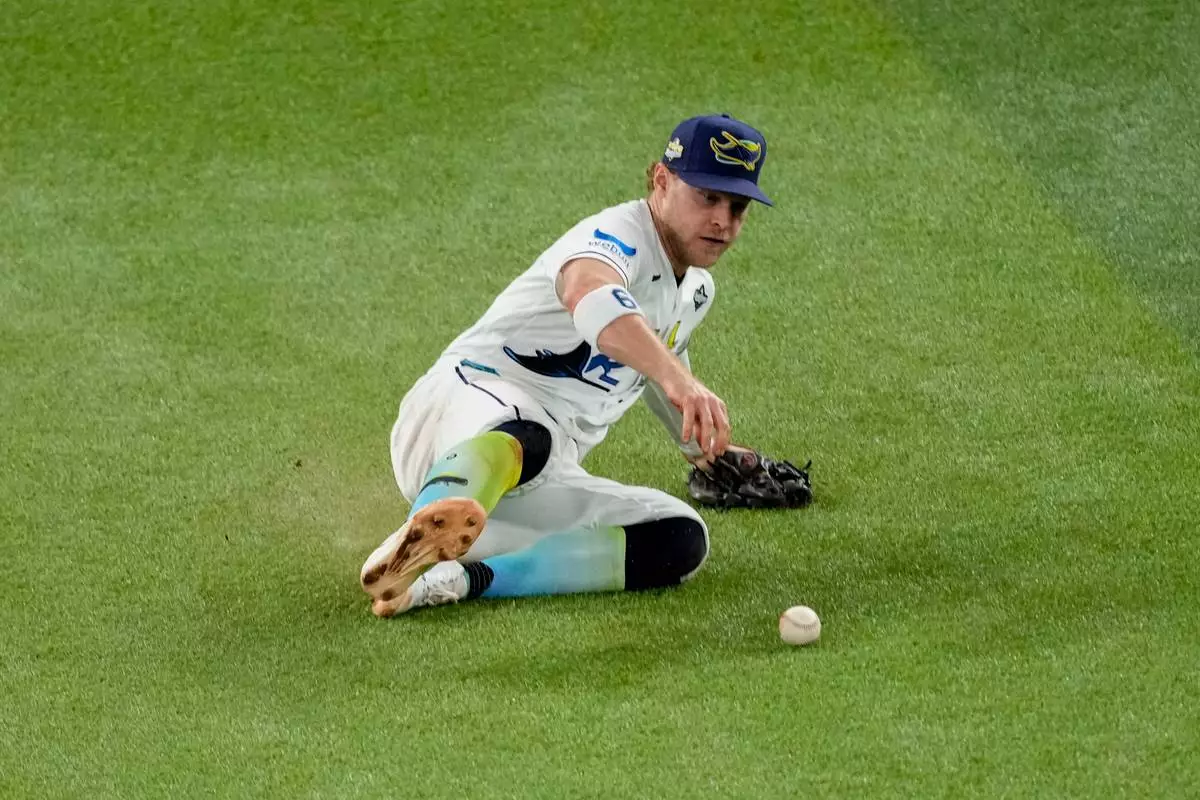 Tampa Bay Rays shortstop Taylor Walls fields a two-RBI base hit by Milwaukee Brewers second baseman Brice Turang during the fifth inning of Game 3 of baseball's World Series, Monday, Oct. 26, 2026, in St. Petersburg, Fla., between the Milwaukee Brewers and the Tampa Bay Rays. (AP Photo/Morry Gash)