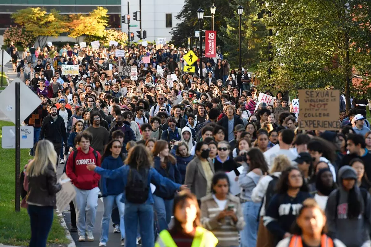 Demonstrators march during a protest against Cornell University's handling of the 2024 fraternity-house gang rape allegations at the campus, Monday, Oct. 5, 2026, in Ithaca, N.Y. (AP Photo/Adrian Kraus)