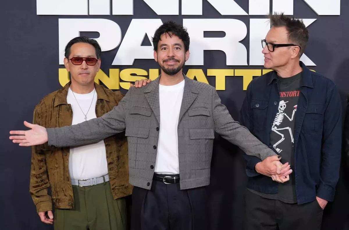 Mike Shinoda, center, and Joe Hahn, left, members of the band Linkin Park, pose with Mark Hoppus, a member of the band Blink-182, at the premiere of the documentary film "Linkin Park: Unshatter" on Thursday, Sept. 24, 2026, at AMC The Grove 14 in Los Angeles. (AP Photo/Chris Pizzello)