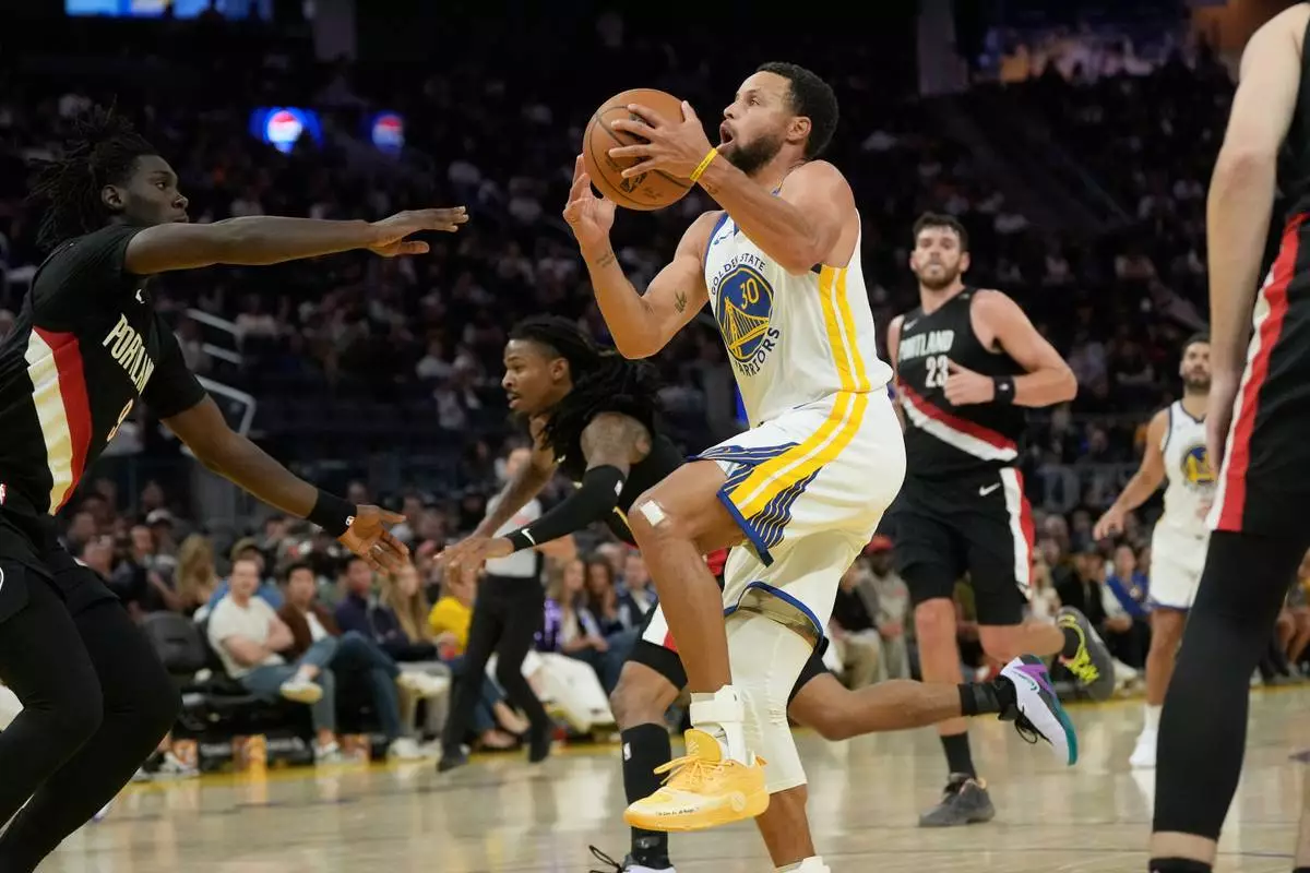 Golden State Warriors guard Stephen Curry (30) drives to the basket against the Portland Trail Blazers during the second half of a preseason NBA basketball game, Friday, Oct. 16, 2026, in San Francisco. (AP Photo/Jeff Chiu)