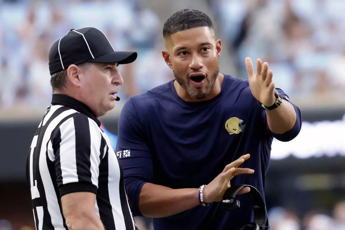 Notre Dame head coach Marcus Freeman discusses a call with an official during the first half of an NCAA college football game against North Carolina, Saturday, Oct. 3, 2026, in Chapel Hill, N.C. (AP Photo/Chris Seward)