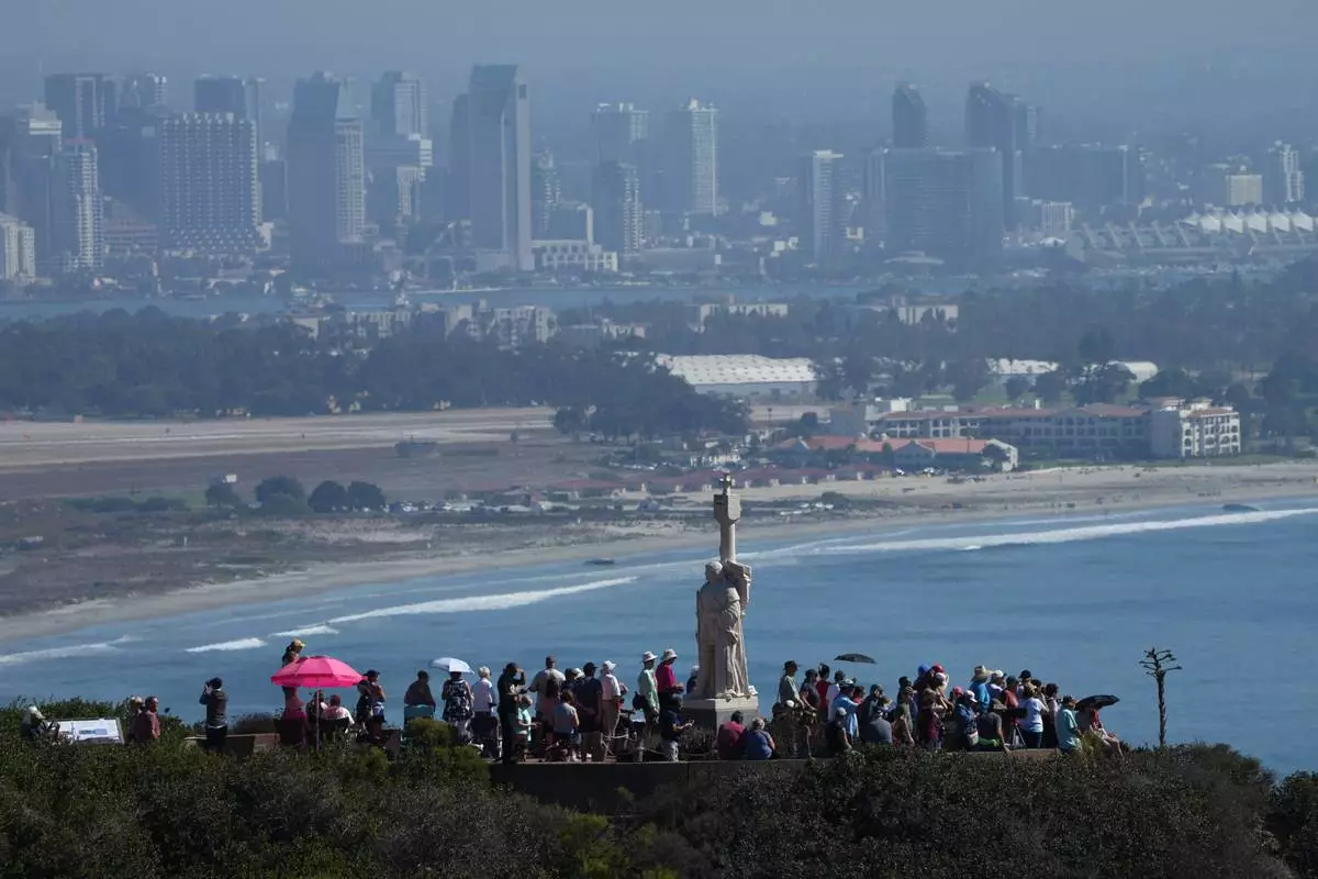 Spectators gather to view the USS Abraham Lincoln aircraft carrier as it returns to the San Diego Bay after deployment Thursday, Oct. 8, 2026, in San Diego. (AP Photo/Jae C. Hong)