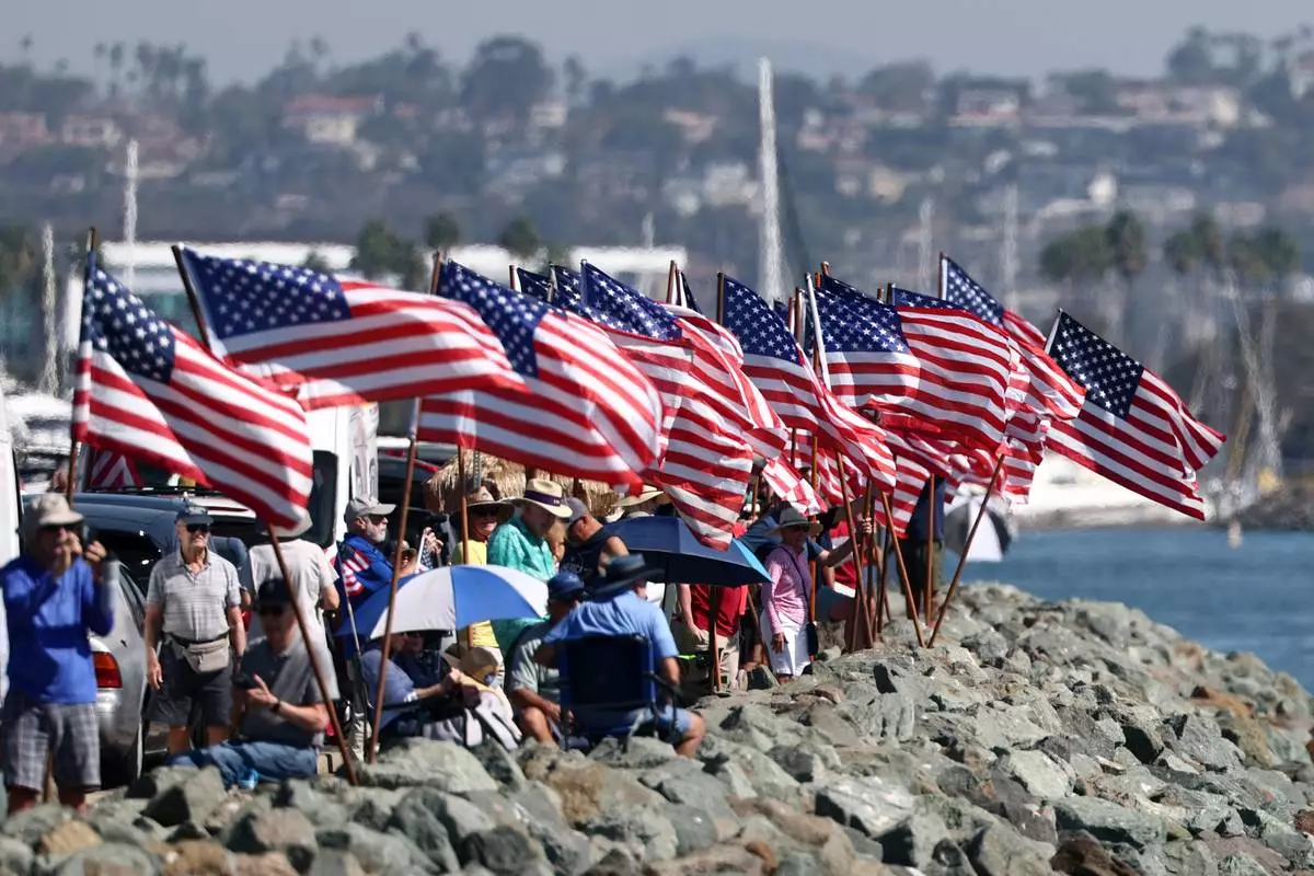 Spectators gather to view the USS Abraham Lincoln aircraft carrier as it returns to the San Diego Bay after deployment Thursday, Oct. 8, 2026, in San Diego. (AP Photo/Karl Anderson)